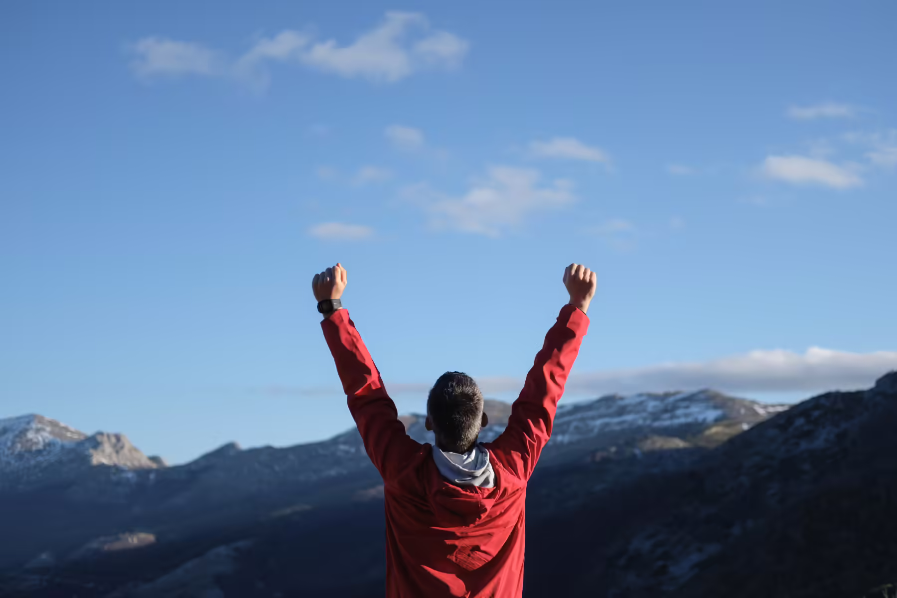 Why You Need to Set Goals with Employee Advocacy 1 Man with hands in air on mountain