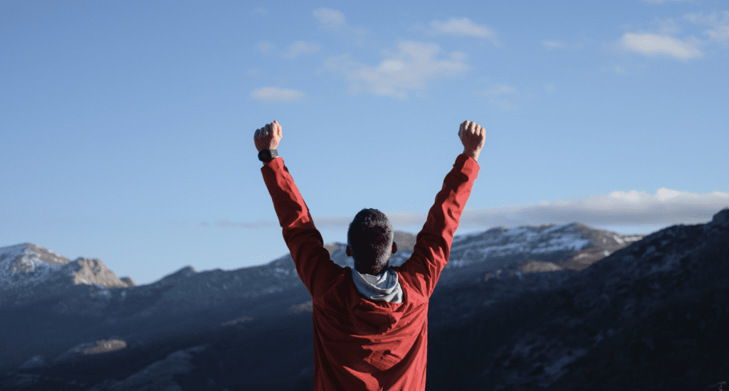 Man hands in air on mountain