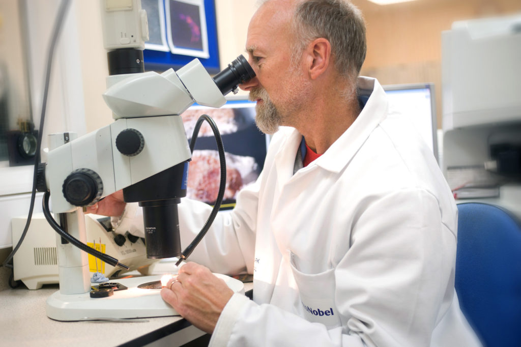 AkzoNobel scientist looking into microscope AkzoNobel scientist looking into microscope