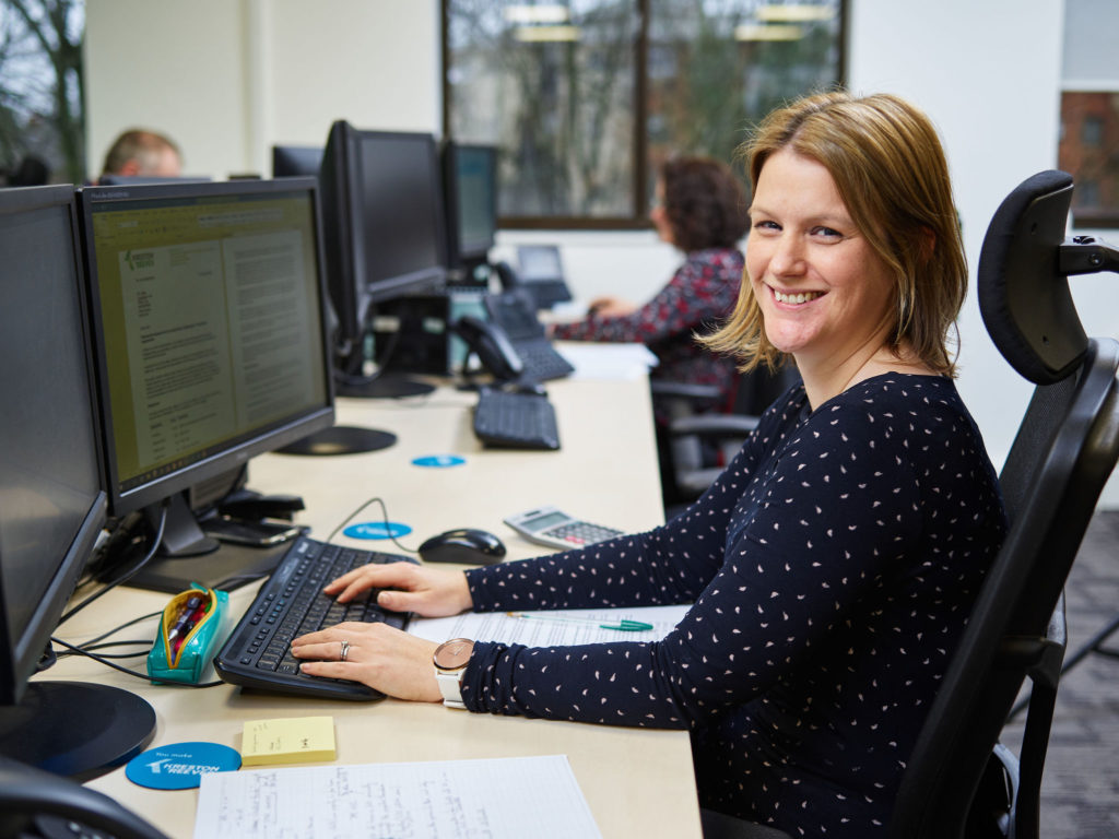 DSMN8 x Kreston Reeves (Case Study Images - Employee) Smiling woman using computer at work for employee advocacy