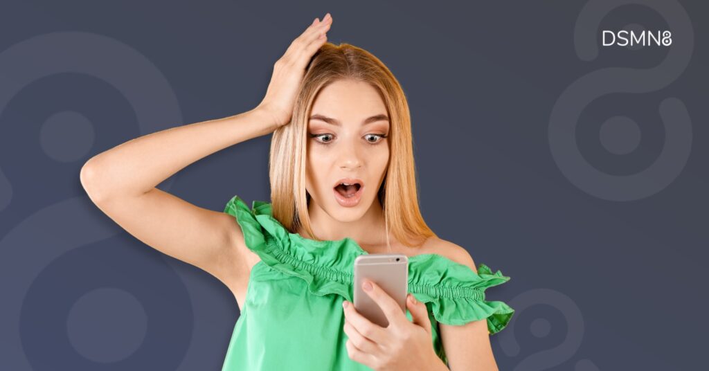woman looking surprised at her phone