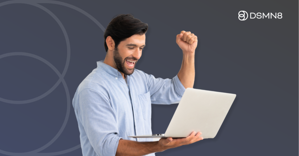 man holding laptop celebrating success